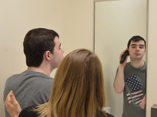 Student shaves as therapist watches him