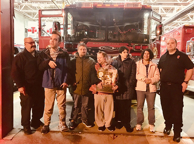 Adult residents in front of fire truck at Burlington station