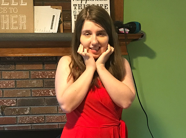 Young woman standing in front of fireplace