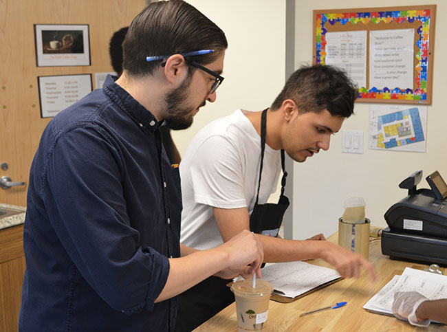 Student working with staff at the coffee shop