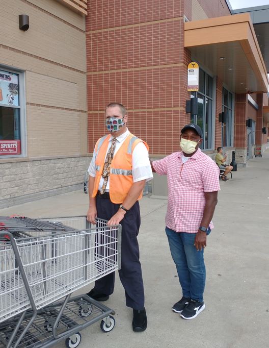 Evan T. stands with his job coach outside of Market Basket in Waltham