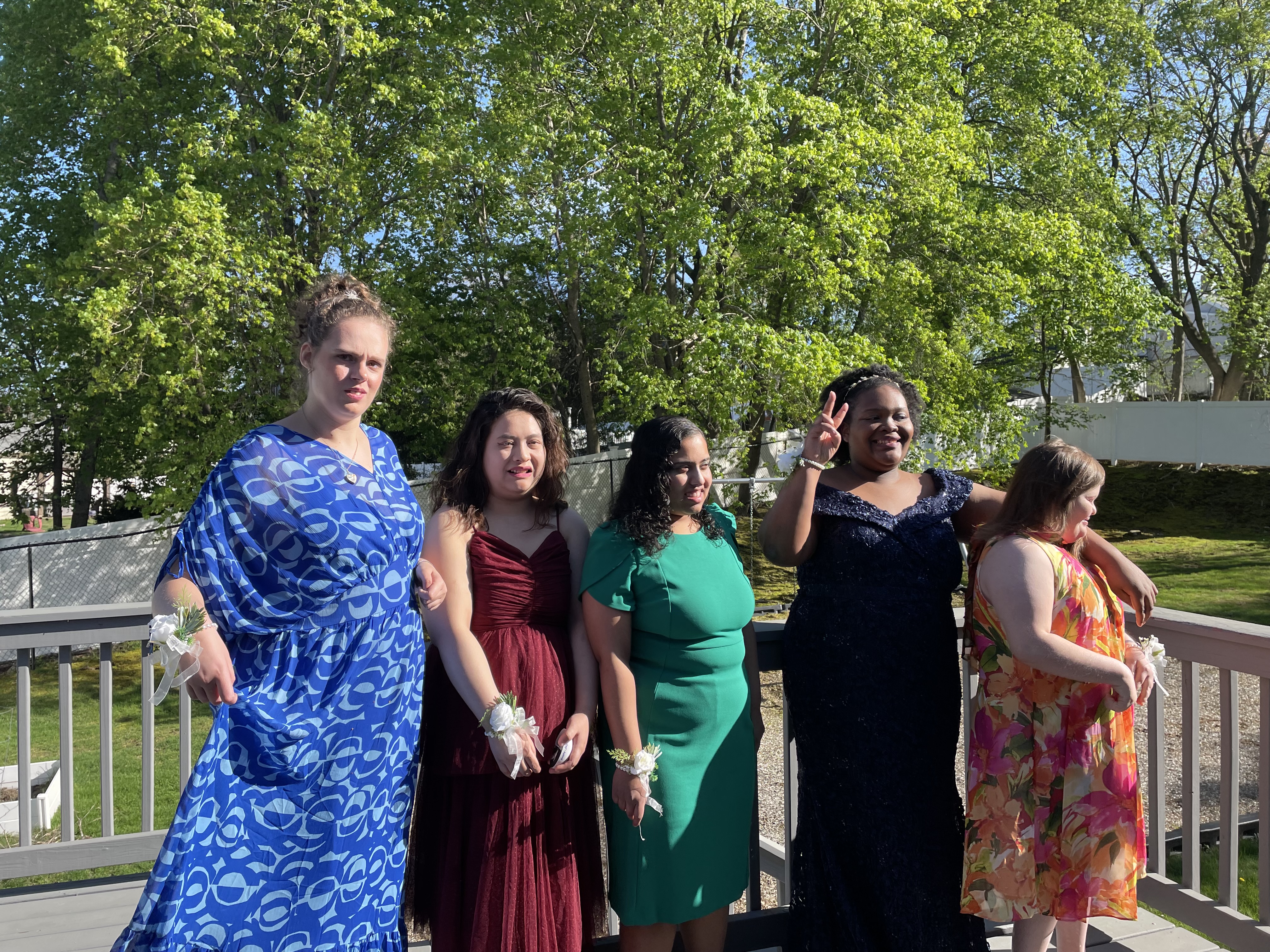 The 5 residents of Waltham 1 House stand together in their colorful dresses on the back porch on a sunny evening before heading to The Guild's spring dance.