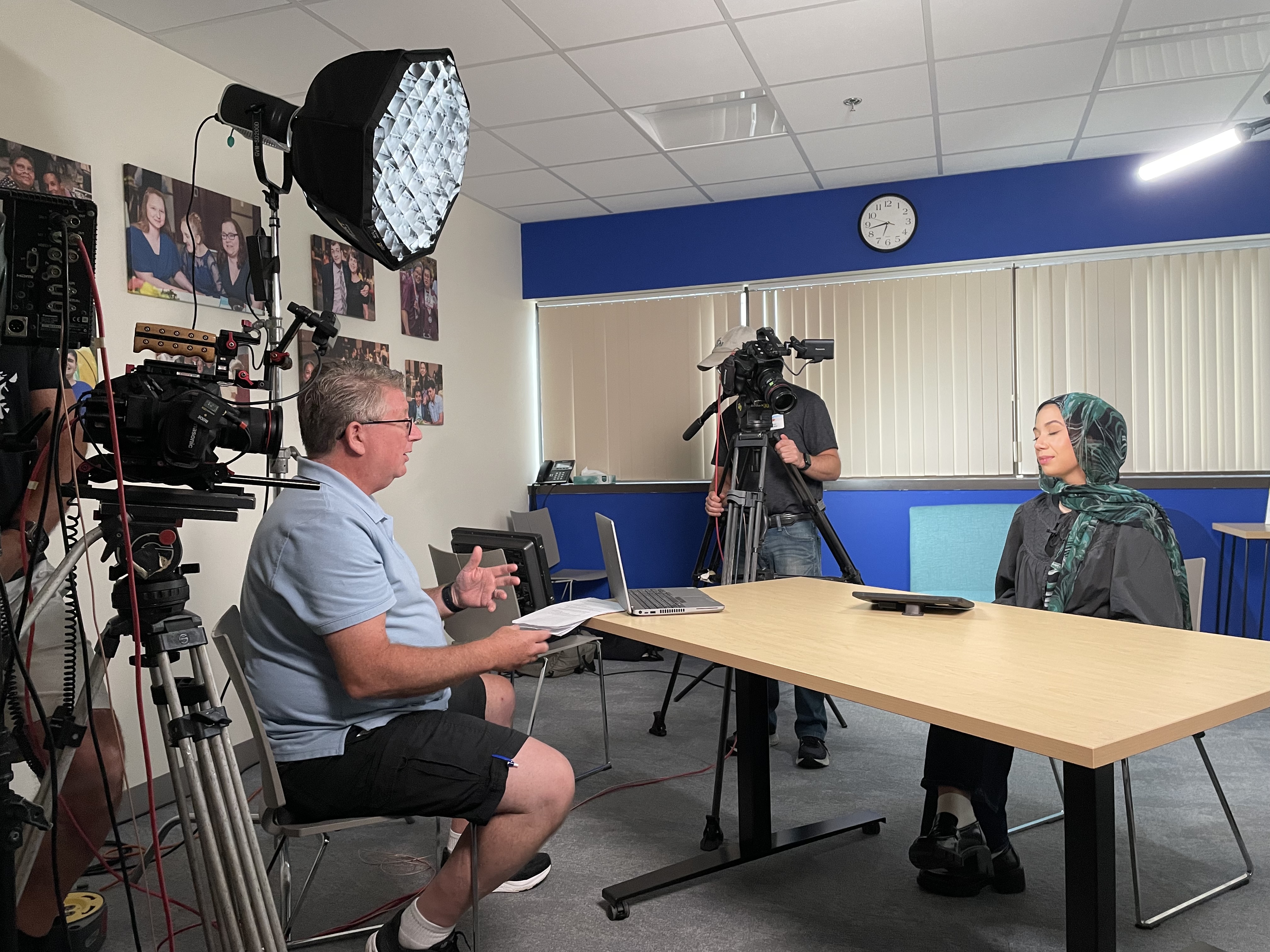 Camera equipment is set up in a small room with a table to record an interview with a Guild staff member.