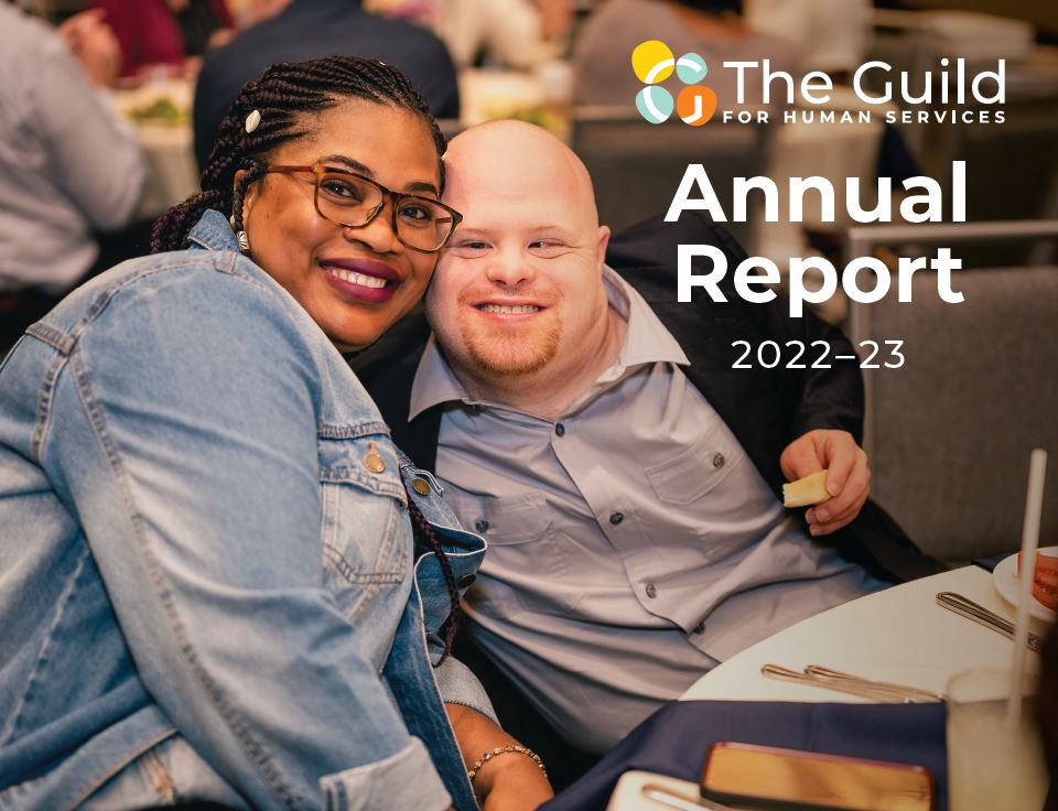 Annual Report 2022-23 cover photo: An adult resident and staff member at The Guild's annual awards ceremonies