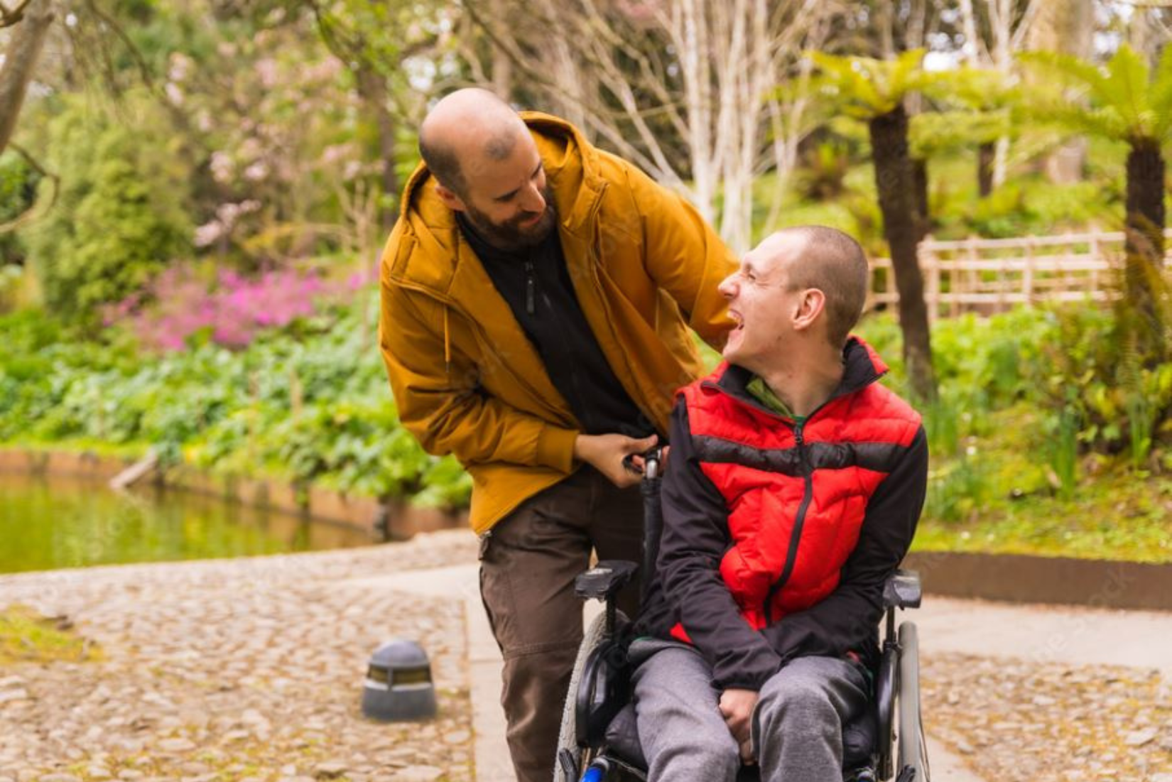 Man in wheelchair with adult next to him