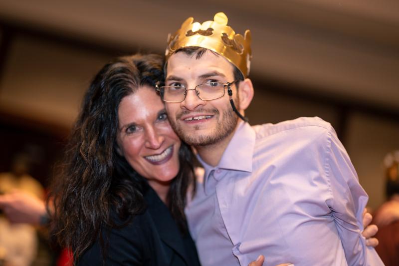 One of The Guild's nurses and an adult resident hug each other and smile at the camera.