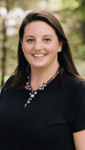 Chelsey Barbaro stands outside and smiles into the camera standing.