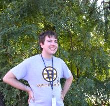 Thomas K. stands outside in front of a tree