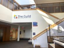 Guild School lobby with sign and staircase